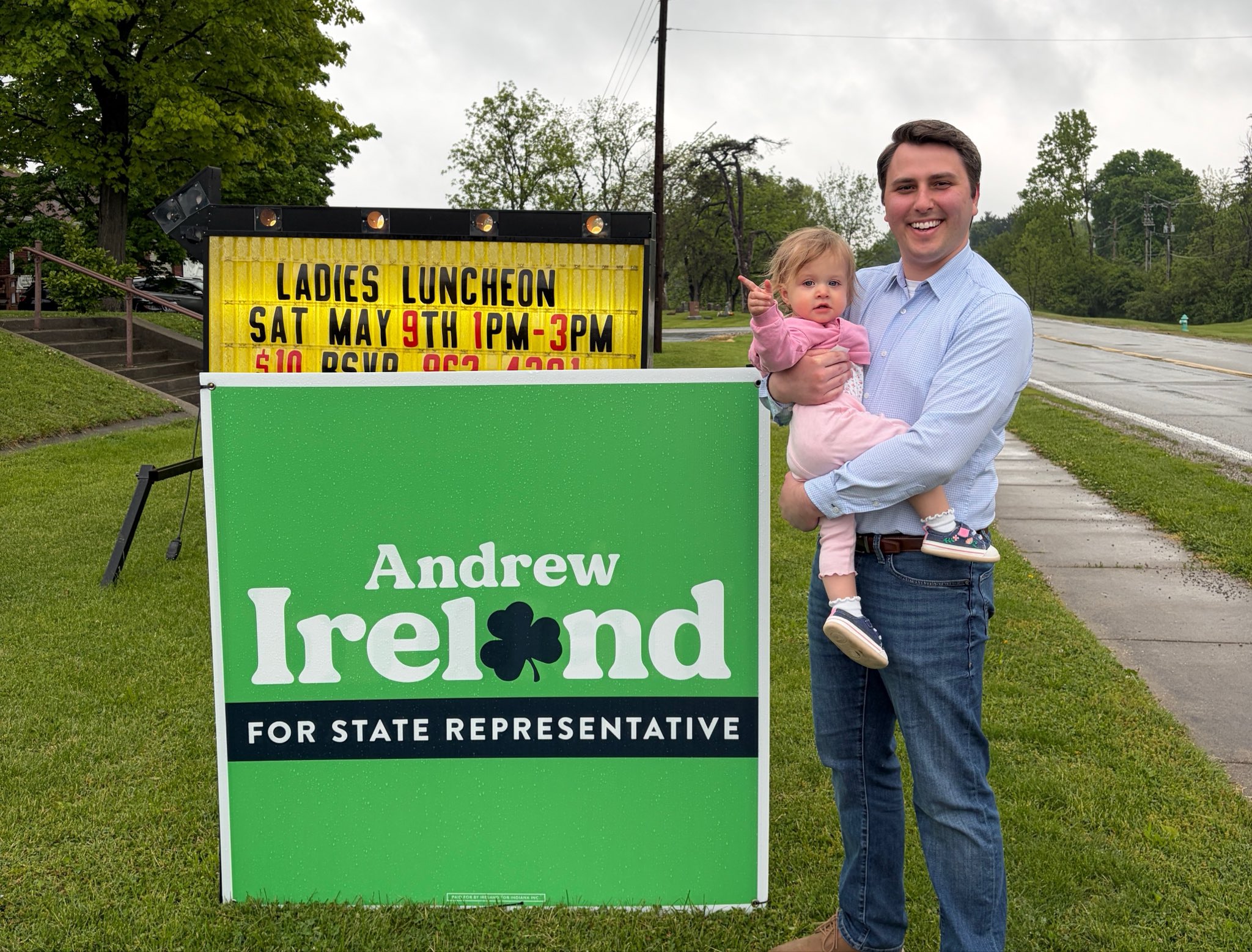 Andrew Ireland and his daughter beside an Ireland campaign yard sign